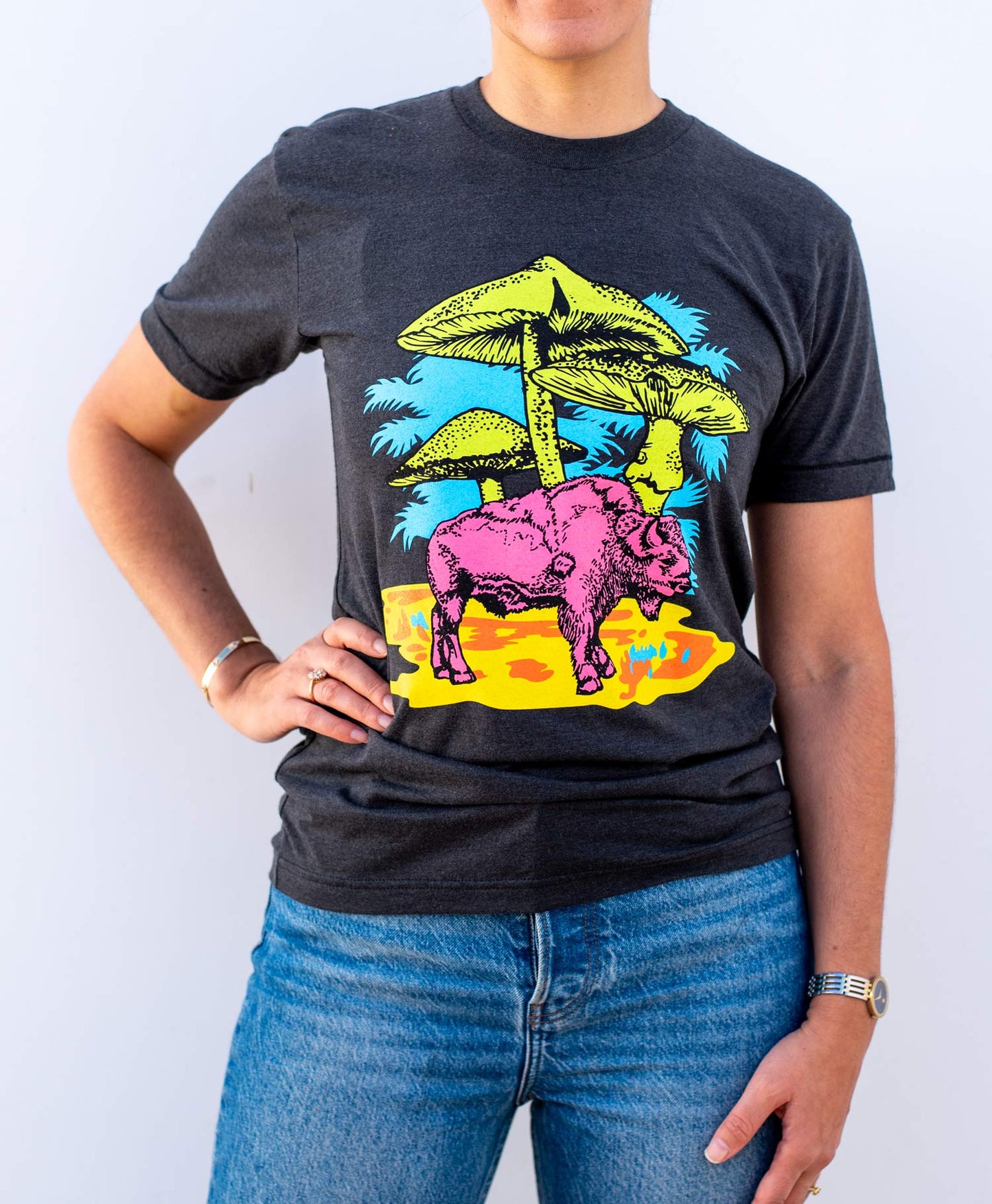 Woman wearing a black shirt with a pink buffalo and mushrooms.