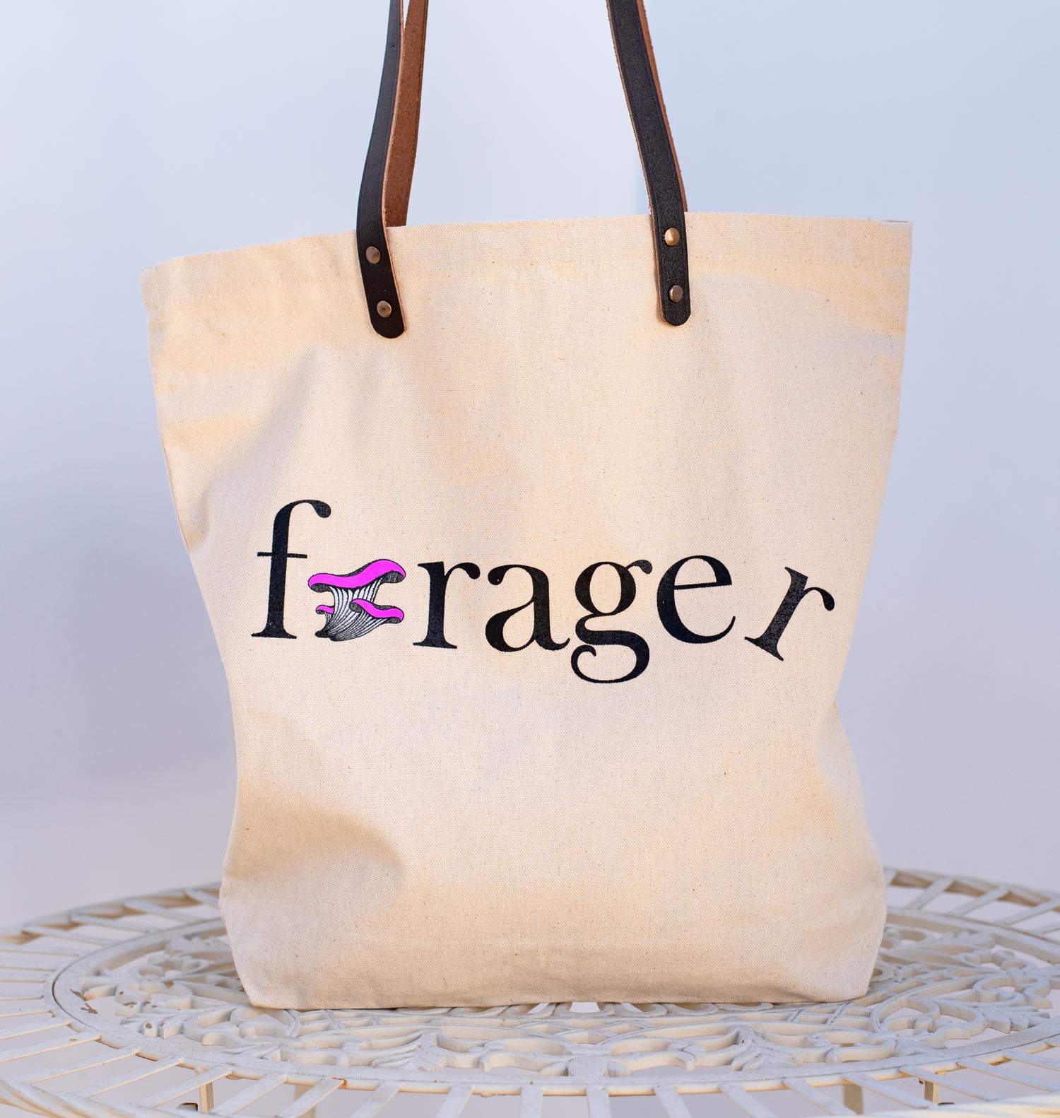 Canvas tote bag with forager printed on the side with a mushroom for the o. 